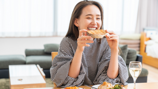 An Asian woman eating crunchy toast looking happy and healthy.