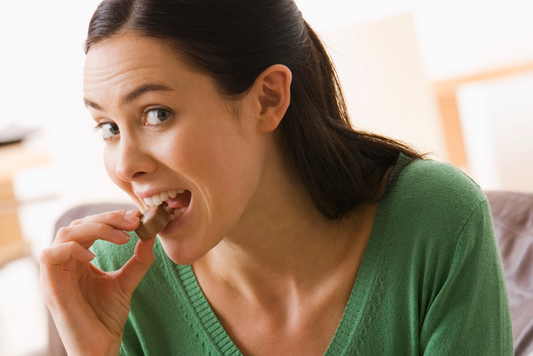Woman eating chocolate secretly.